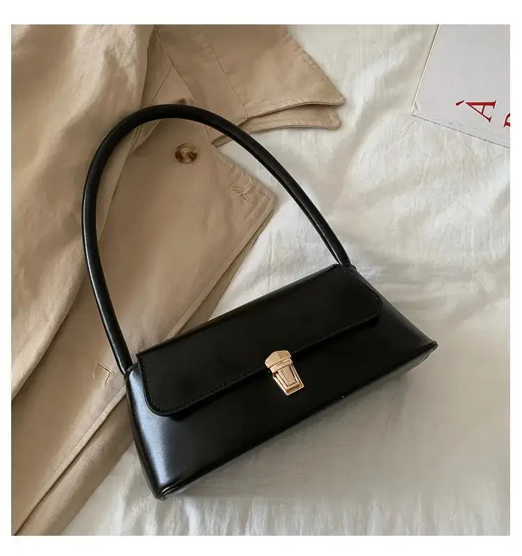 Black faux leather shoulder bag with gold-tone clasp and top handle