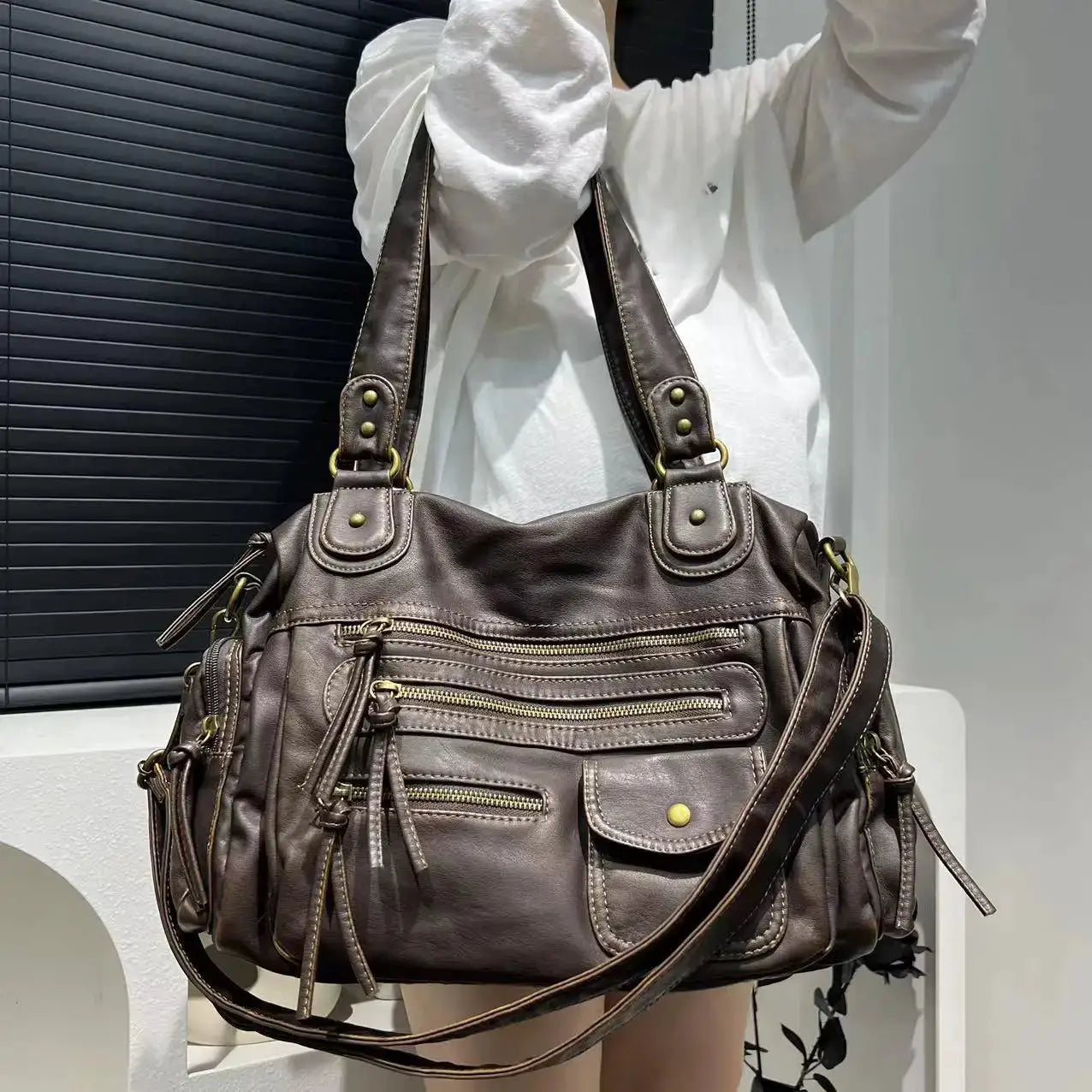 Leather crossbody bag in vintage washed brown with multiple zip pockets and a front flap pocket.