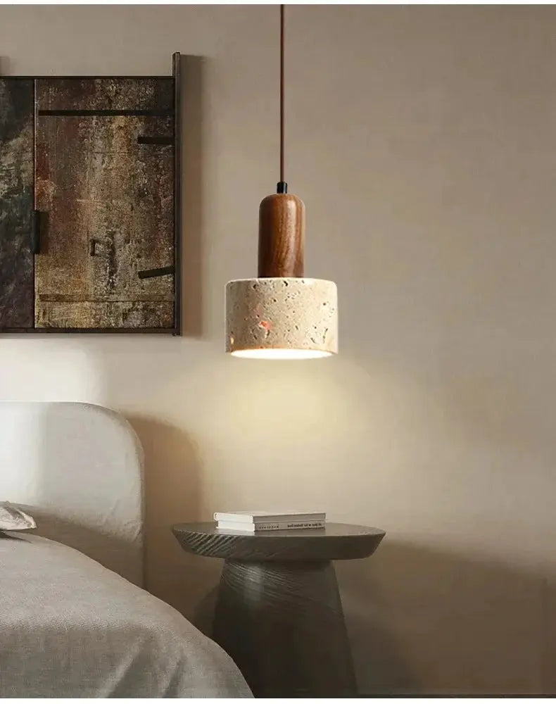 Travertine droplight pendant lamp with a wood top, beige shade with orange flecks over a bedside table