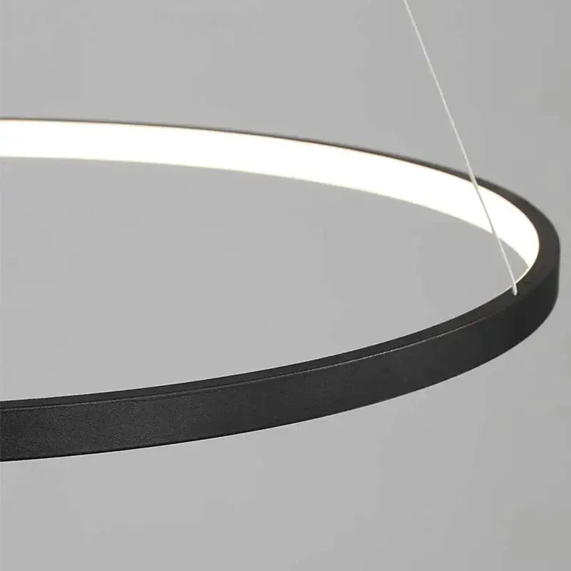 Round LED pendant light with a black metal ring and illuminated white inner edge.