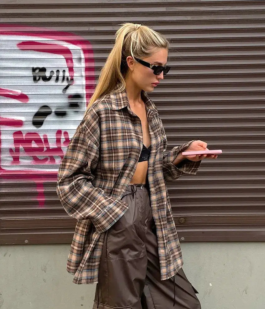 Plaid checkered oversized long-sleeve shirt in beige-brown worn open over a black top
