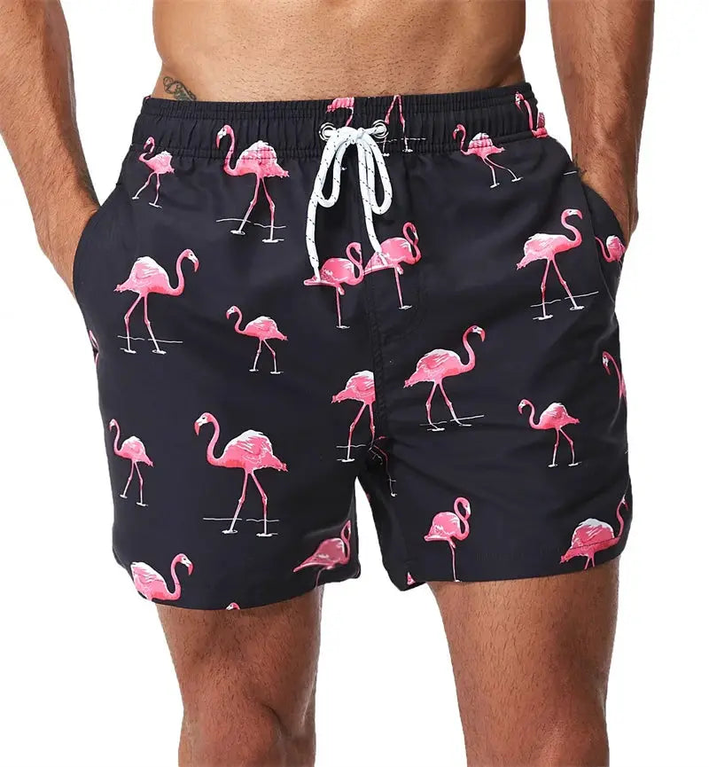 Men's swim trunks by Simples Market with navy fabric, pink flamingo print, and white drawstring