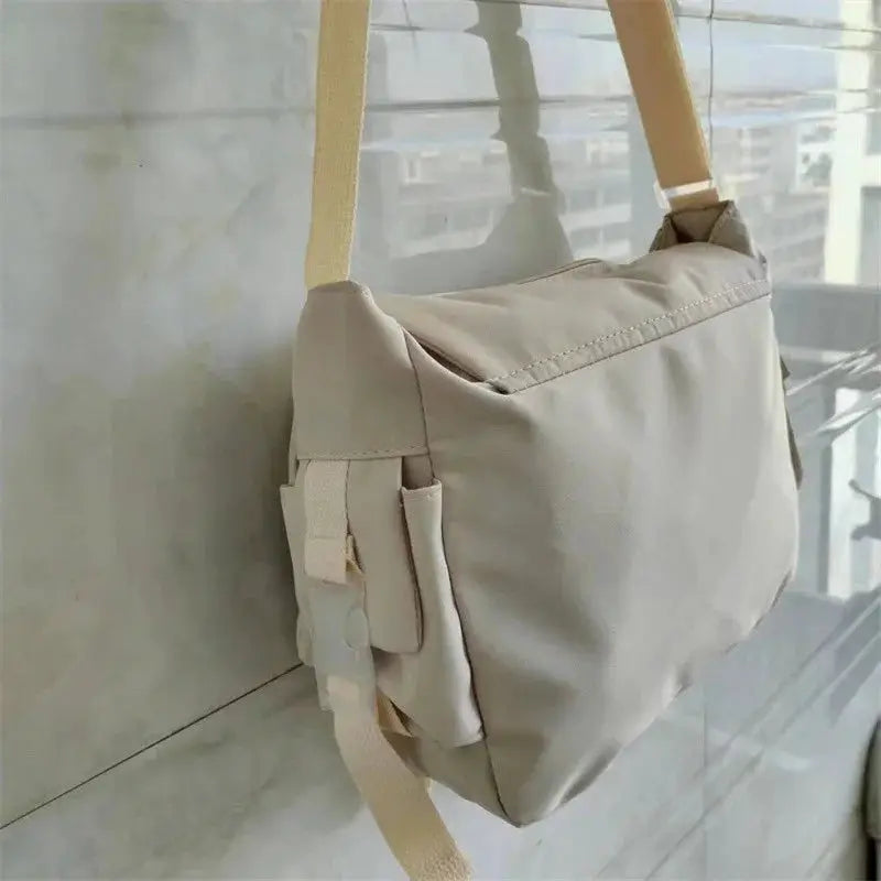 Large capacity beige canvas crossbody bag with adjustable strap and side pocket