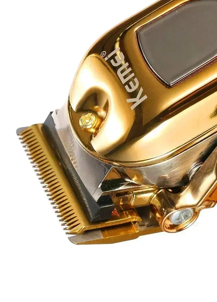 Kemei hair clipper KM-TX1 with gold-silver metal body; rechargeable professional electric trimmer with Kemei branding.