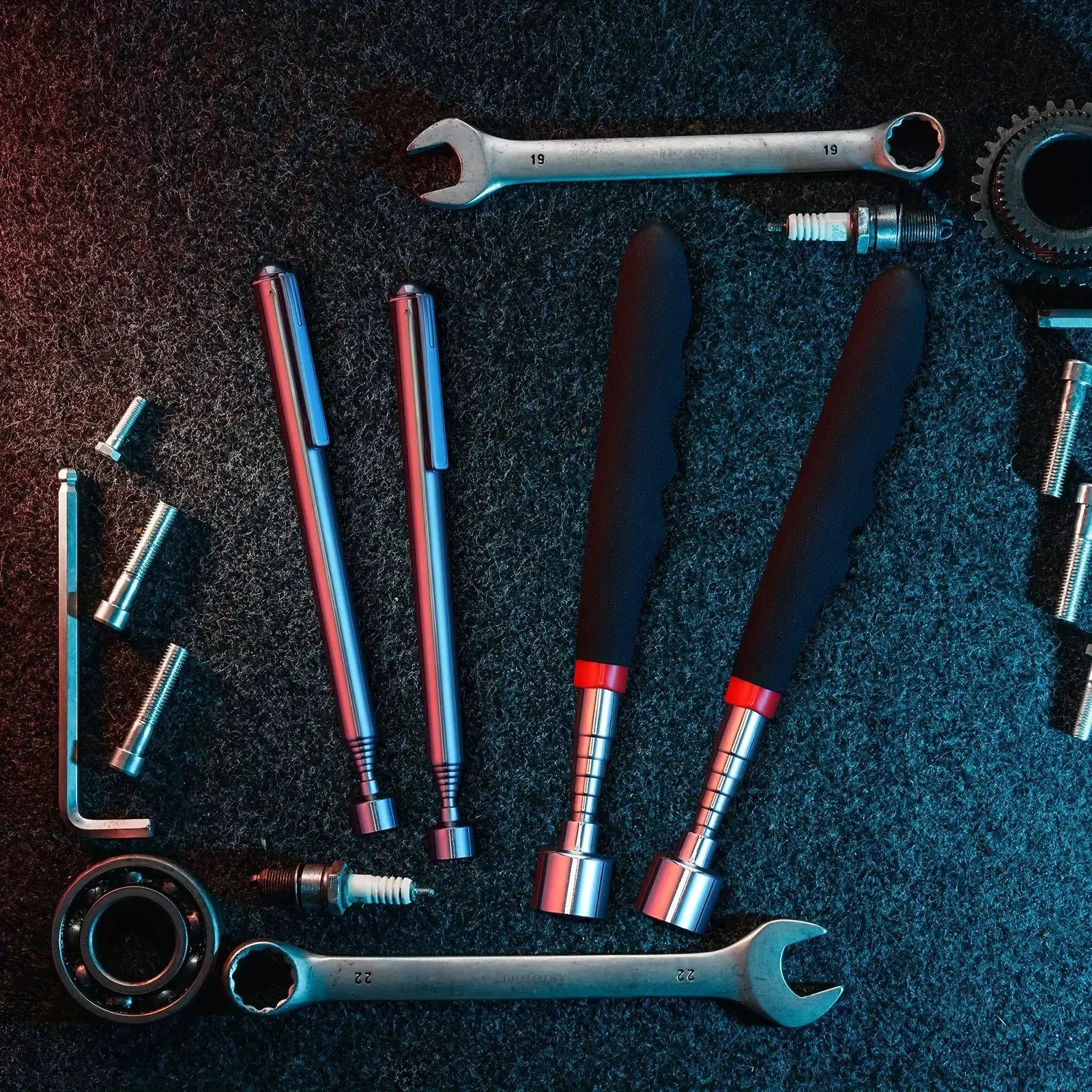 Telescopic magnet picking tool by Simples Market laid out with screwdrivers and wrenches on a workshop surface