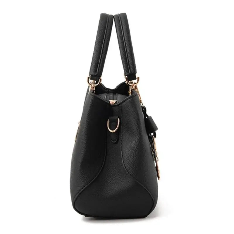Women's black faux-leather handbag with double top handles and gold hardware