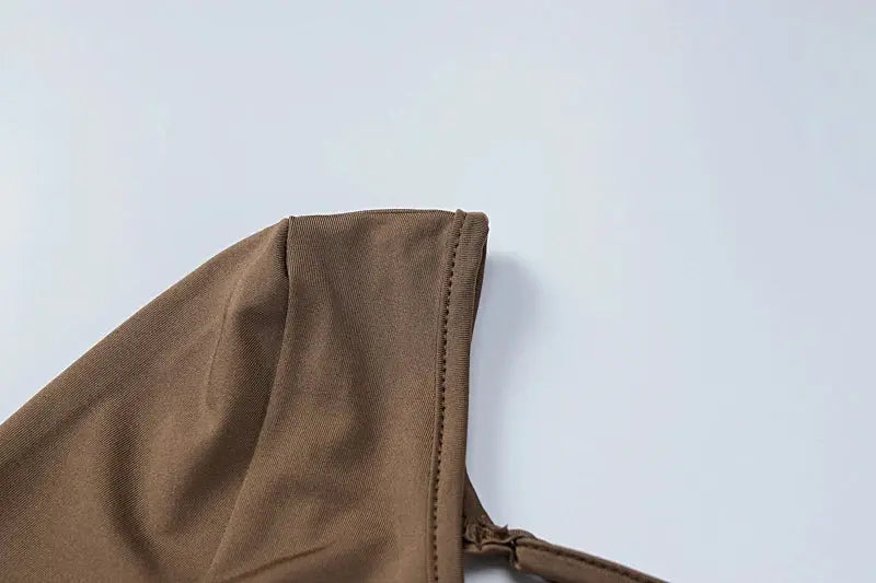 Hugcitar long-sleeve backless playsuit fabric close-up in brown with stitched edge and strap detail