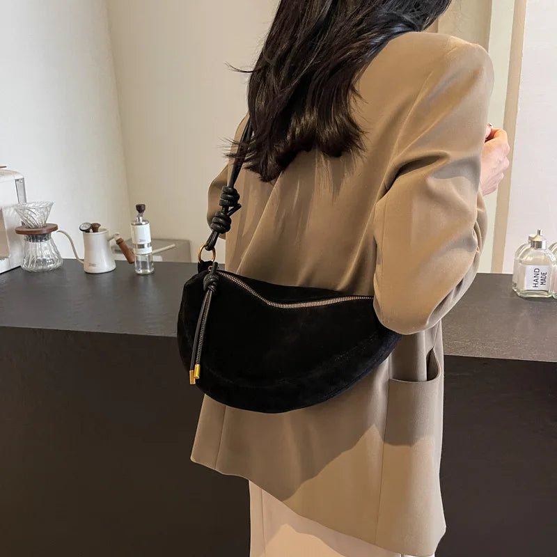 Faux suede black shoulder bag with knotted strap, gold zipper, dumpling-style crossbody