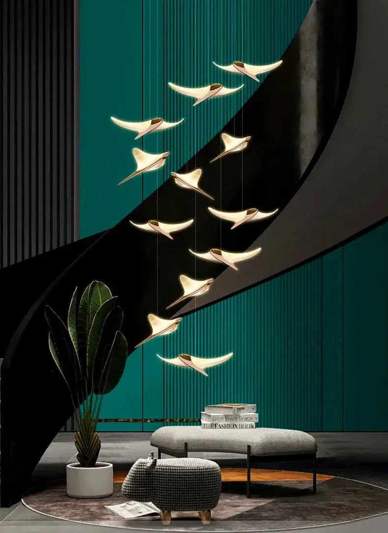 Seagull staircase pendant lamps in gold finish hanging along a curved black staircase in a modern interior