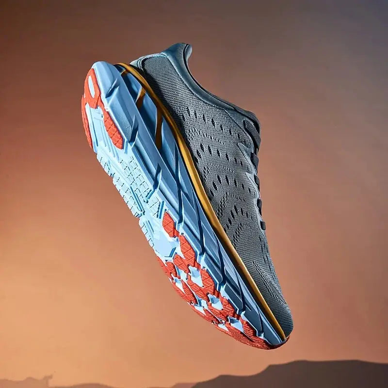 Men's running shoe with gray knit upper, blue outsole, orange traction accents, and gold midsole stripe.