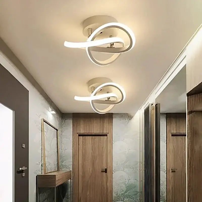 LED ceiling lights with intertwined loop design; modern white ring fixtures, two installed in hallway