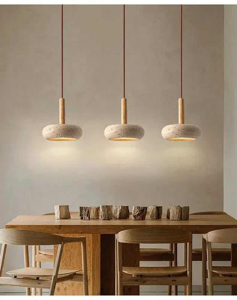 LED pendant lamps: three circular yellow stone fixtures by Simples Market over a wooden dining table