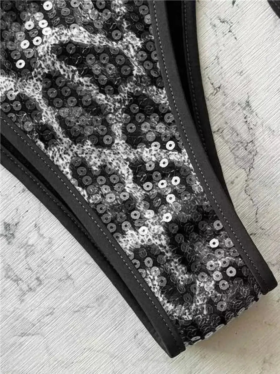 Two-piece sequin bikini set with halter straps in black and silver.