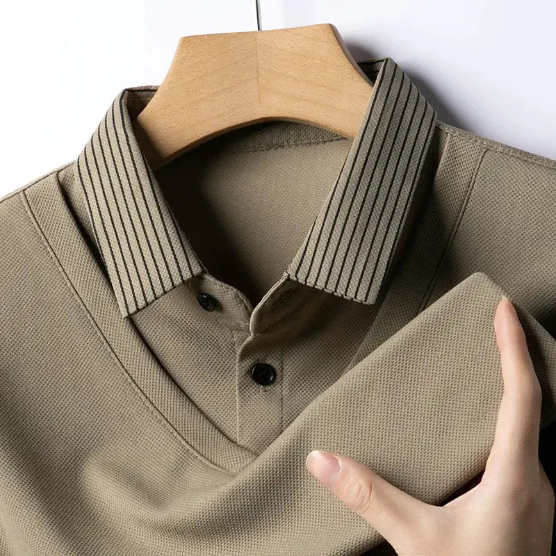 Men's long-sleeve polo shirt in beige with striped collar on a hanger.