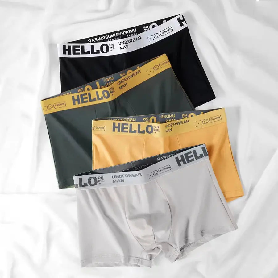 4-pack men's boxer shorts by Simples Market; black, green, mustard, and gray with Hello branded waistbands.