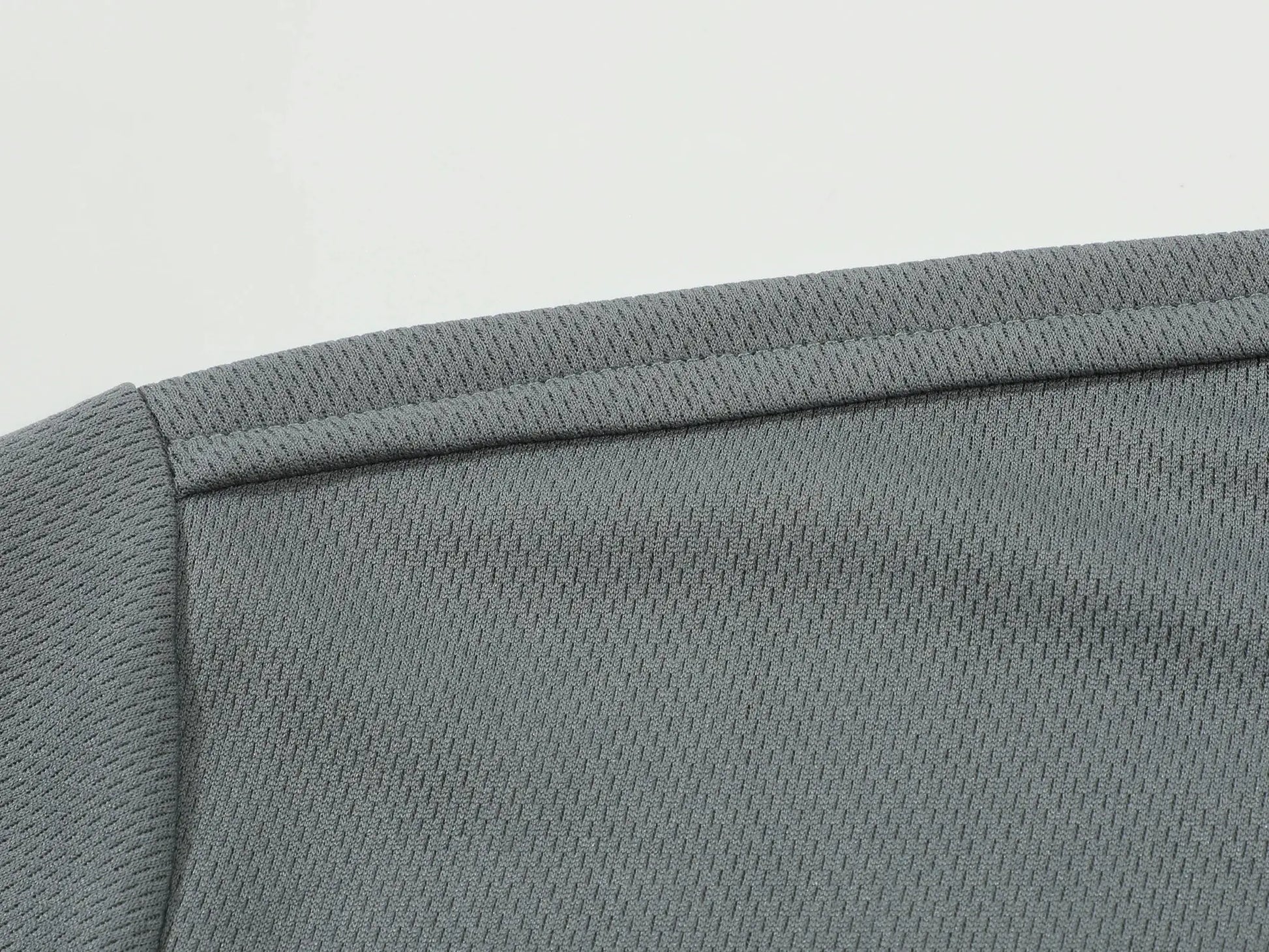 Grey polo shirt sleeve close-up showing ribbed knit fabric texture