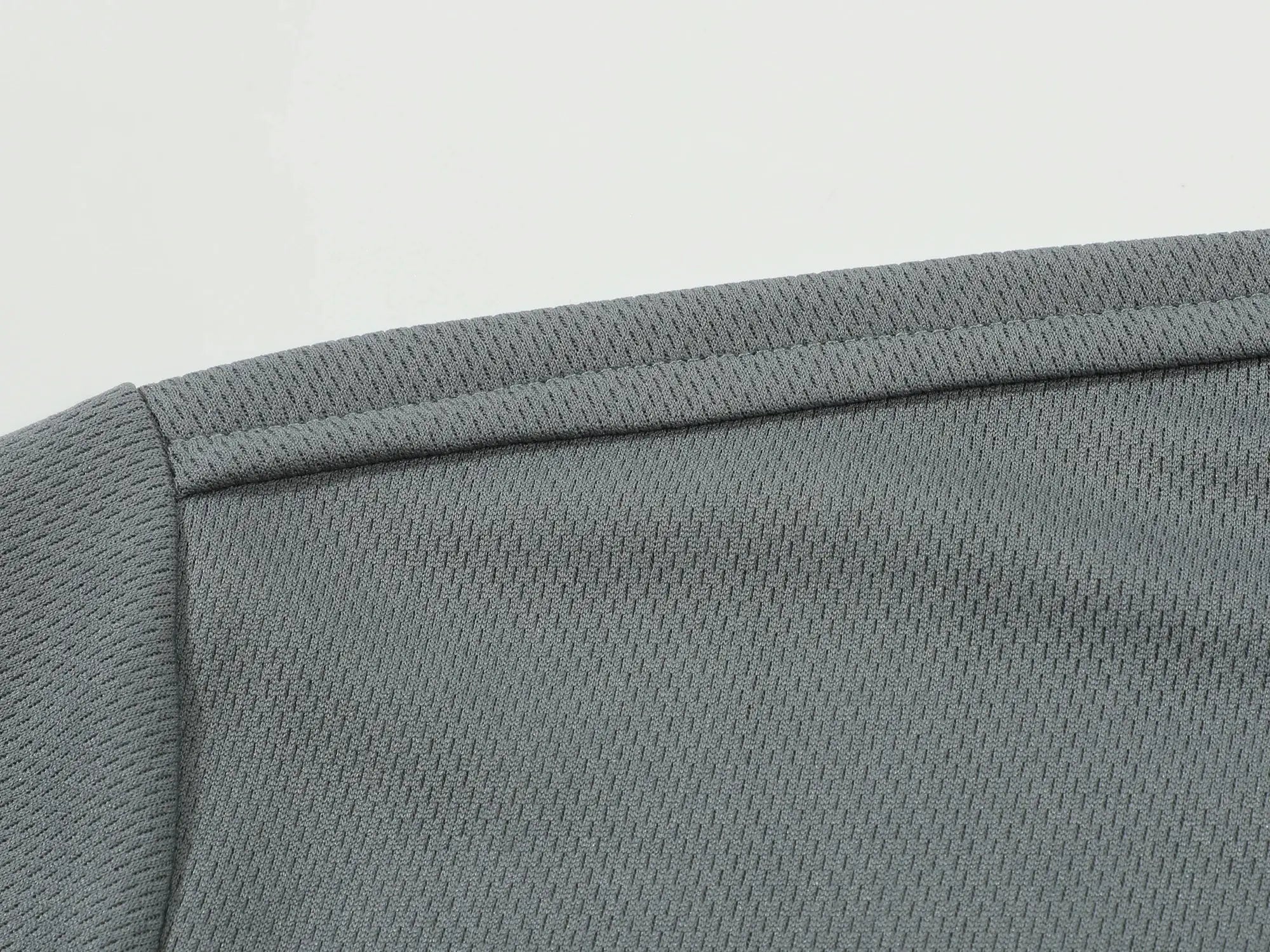 Grey polo shirt sleeve close-up showing ribbed knit fabric texture