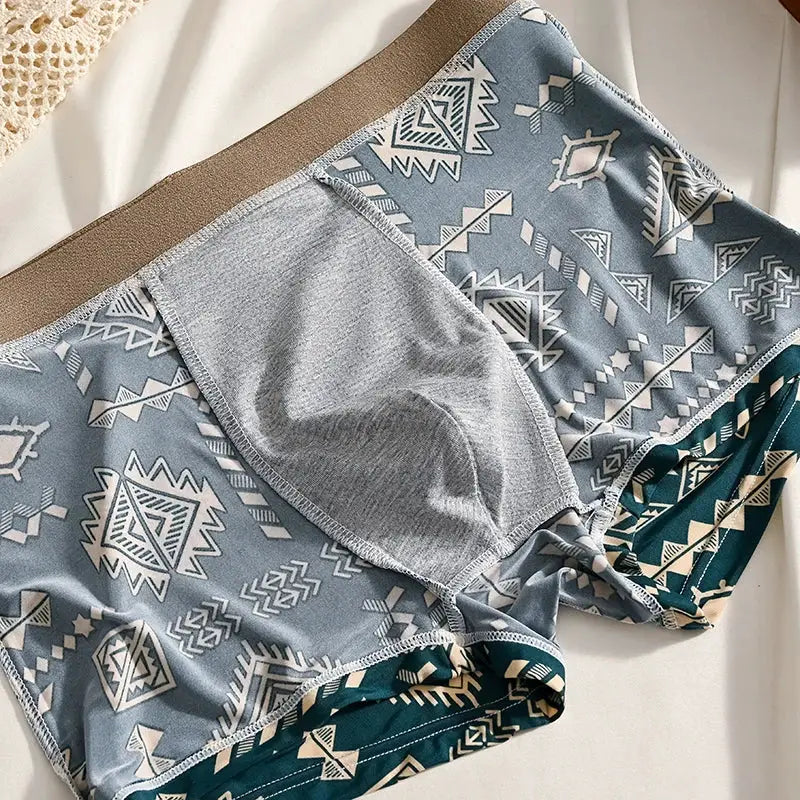 Boxer shorts for men by Simples Market in ice silk with blue geometric print and grey front pouch.