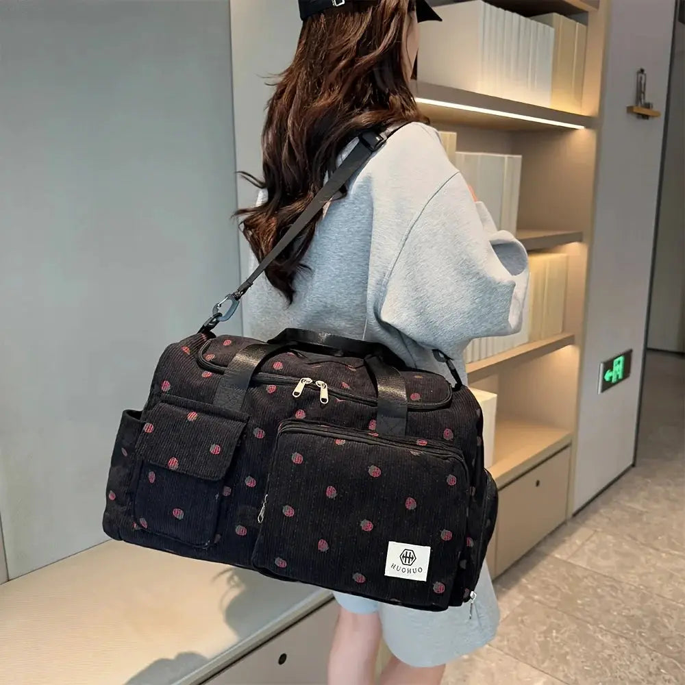 Strawberry-pattern black corduroy travel bag with large main compartment and multiple pockets