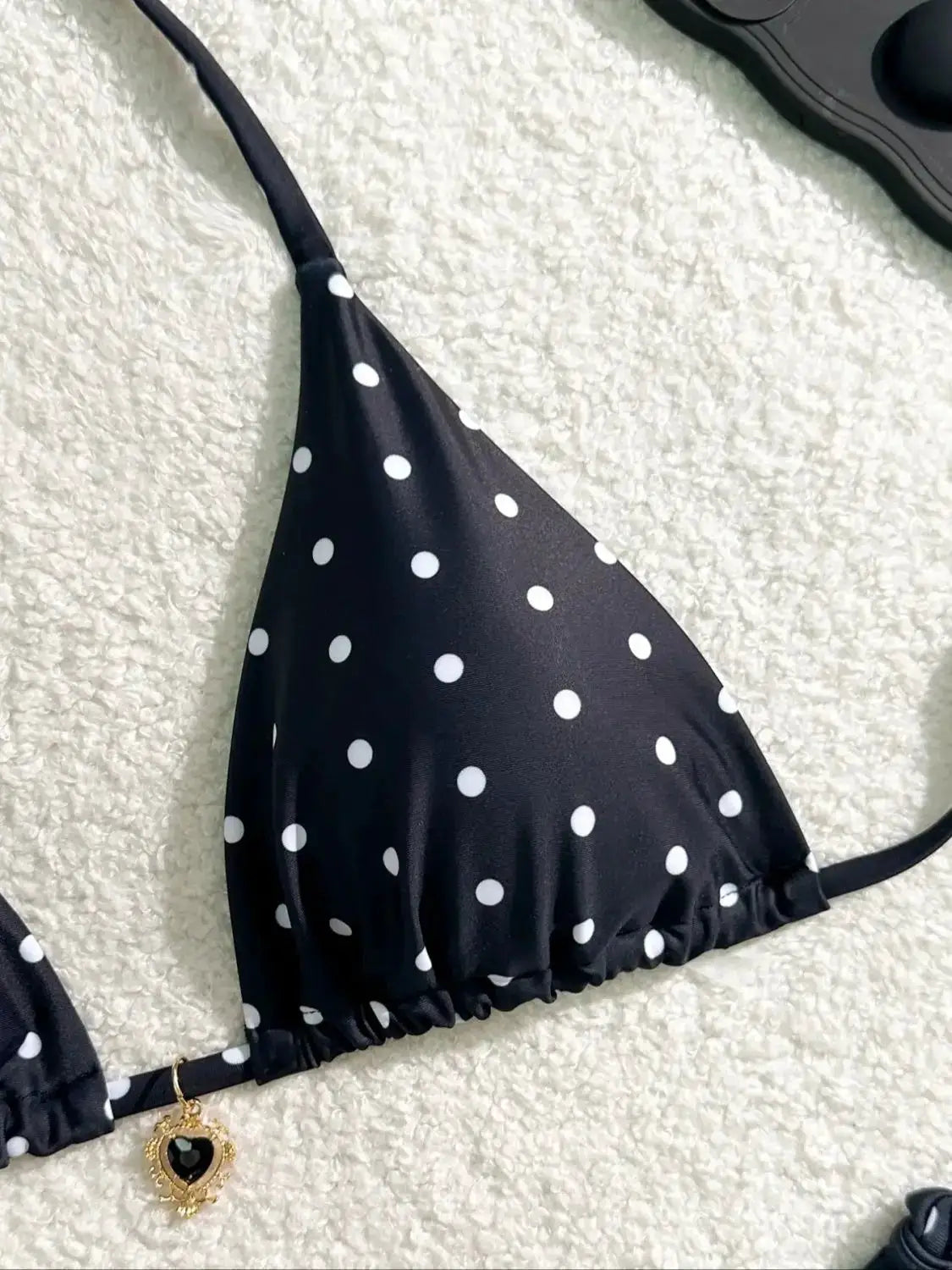Bikini top, black with white polka dots; triangle shape with adjustable straps.
