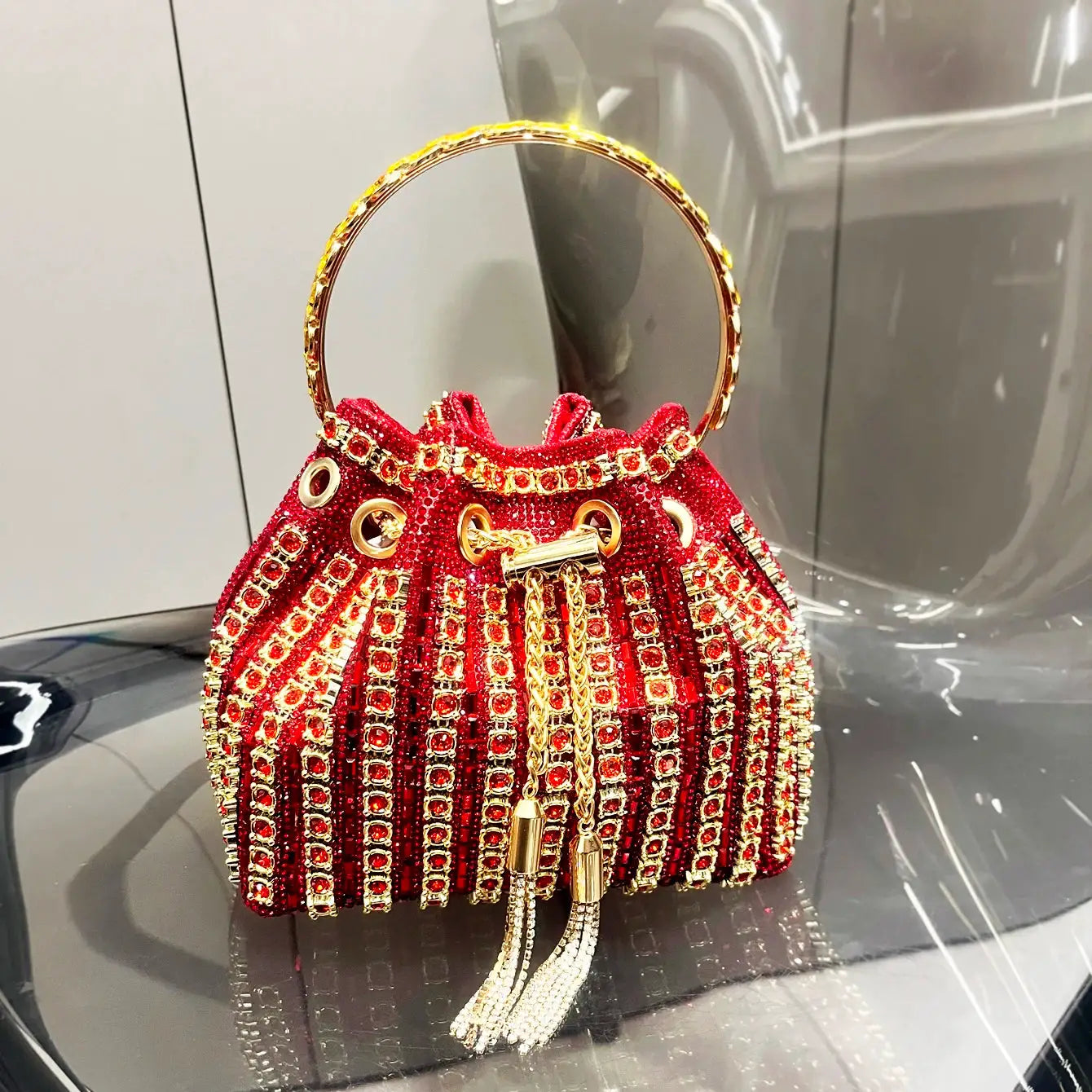 Red crystal rhinestone bucket clutch purse with gold ring handle and tassel fringe