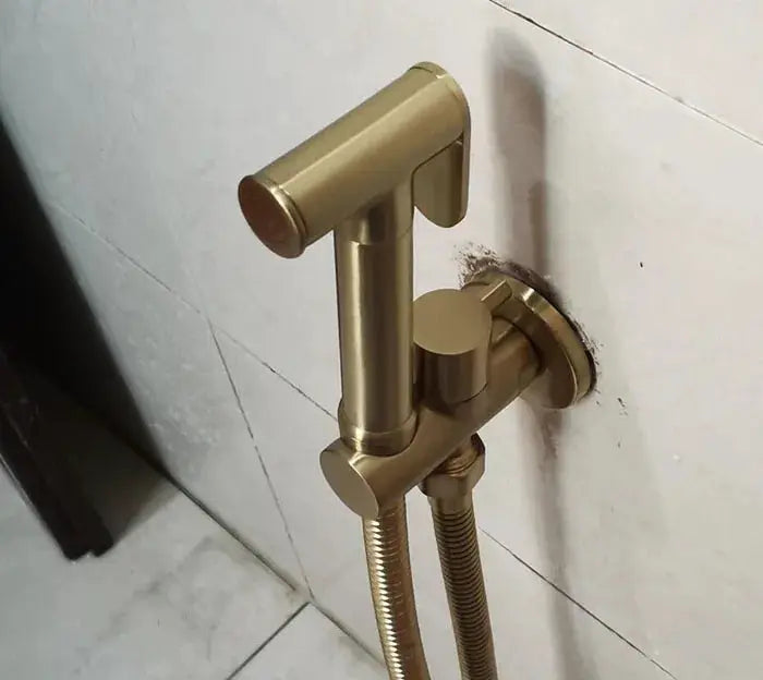 Brass handheld bidet shower set with wall-mounted bracket and flexible hose, brushed gold finish.