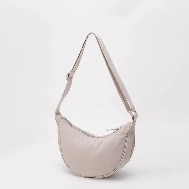Nylon crescent crossbody bag by Simples Market in beige with zipper, large-capacity dumpling style.
