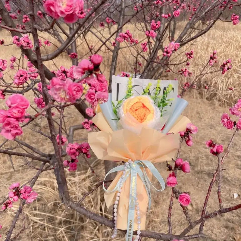 Stuffed plants bouquet by Simples Market; peach rose centerpiece with pastel peach wrapping and pale blue ribbons