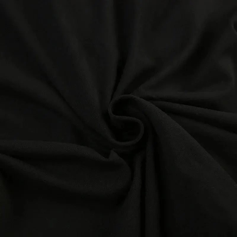Women's black jumpsuit fabric close-up showing folds and texture