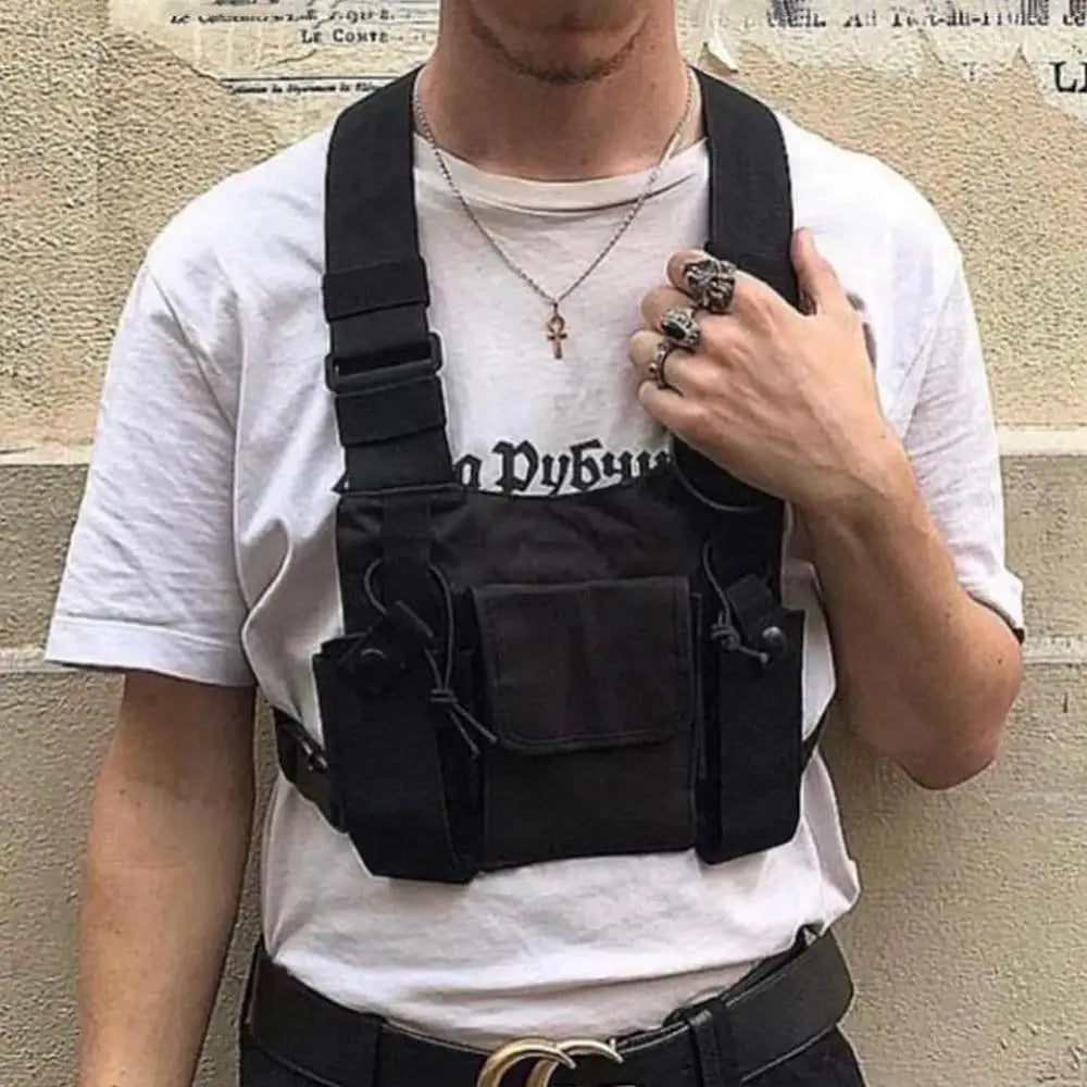 Black tactical chest rig bag worn over a white tee, featuring a front pouch and side pockets