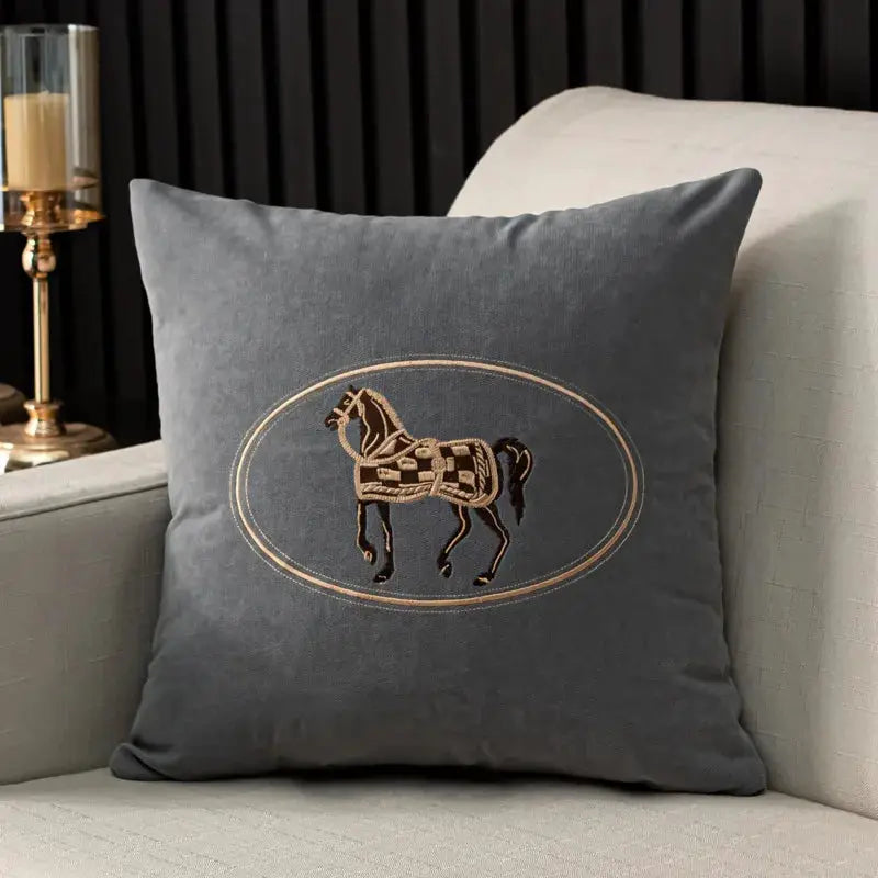 Cushion cover with American hand-embroidered horse design in a gold oval frame on gray fabric, 45x45cm.
