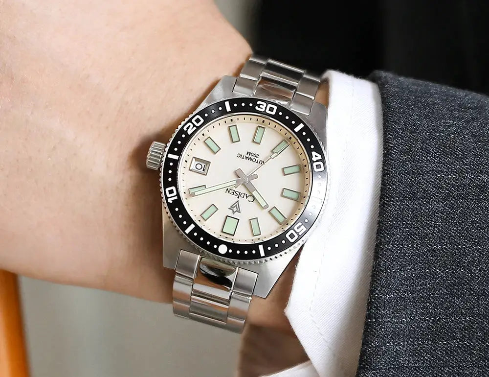 CADISEN 38mm diver watch on stainless steel bracelet with cream dial, luminous markers, black bezel, and date window