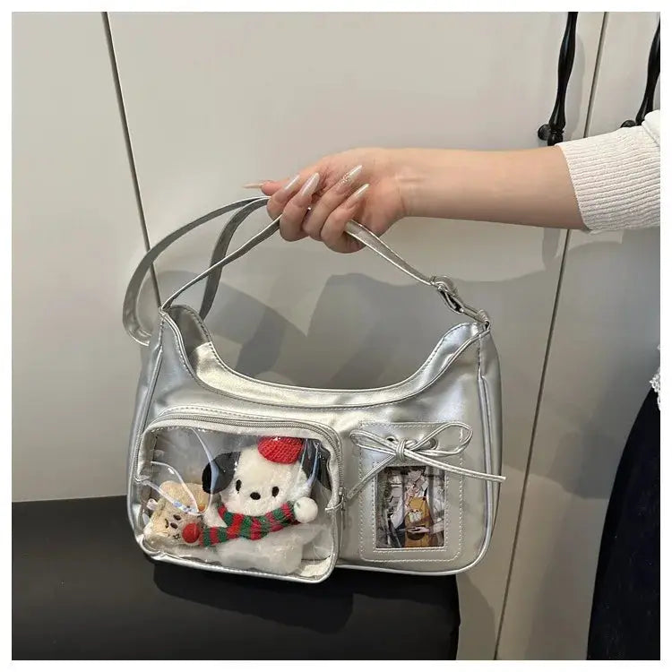 Ita bag silver metallic shoulder crossbody with clear front pockets showing plush toys