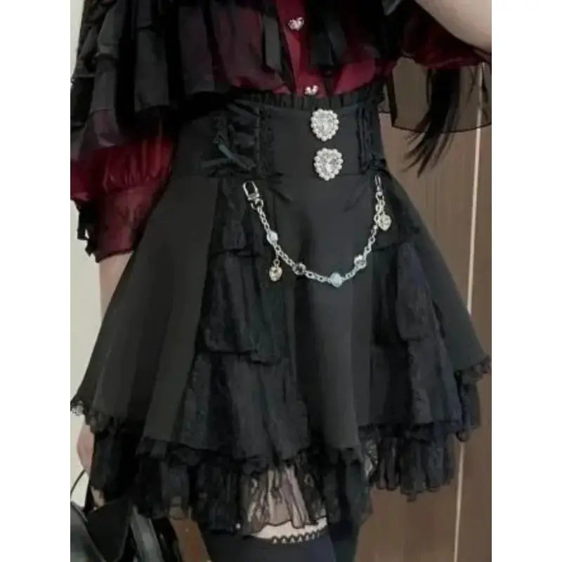 Black lace-tiered Lolita-style skirt with jeweled buttons and a decorative chain belt
