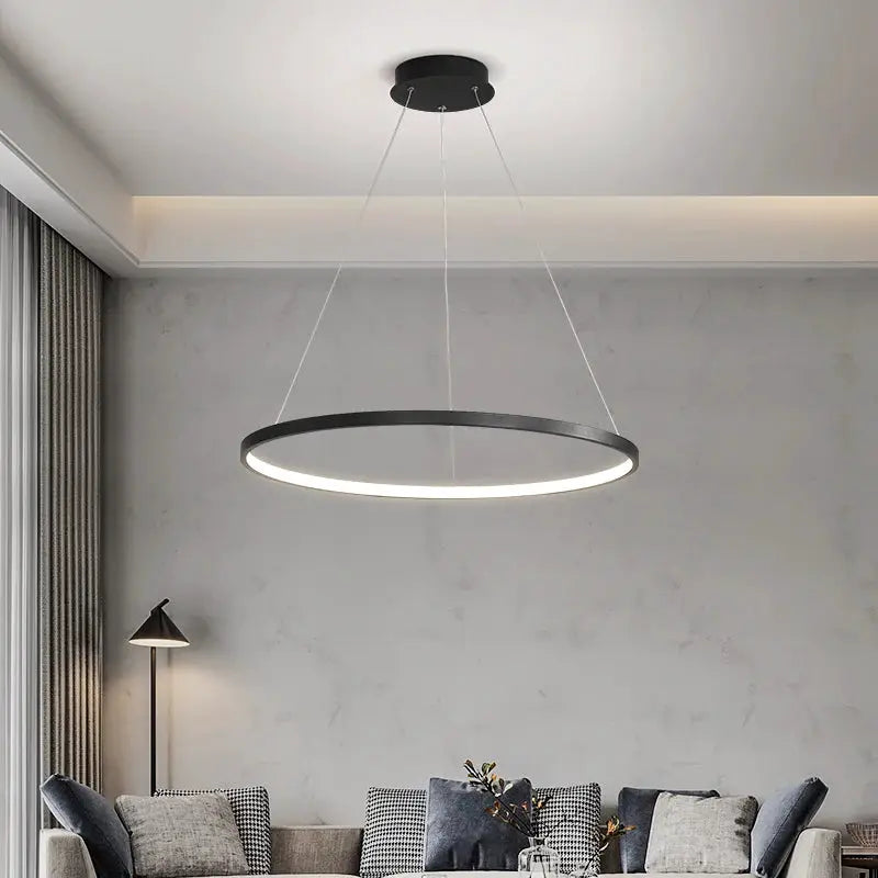 Modern round LED pendant light in black with white illuminated ring; minimalist living room chandelier