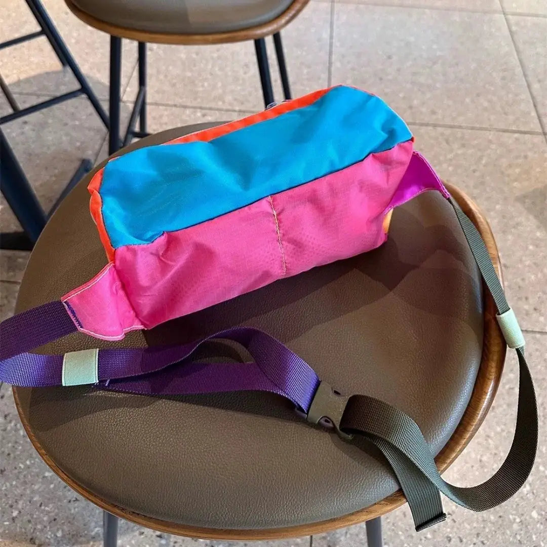 Unisex color-block waist bag with pink-blue pouch and purple strap, ideal for outdoor hiking