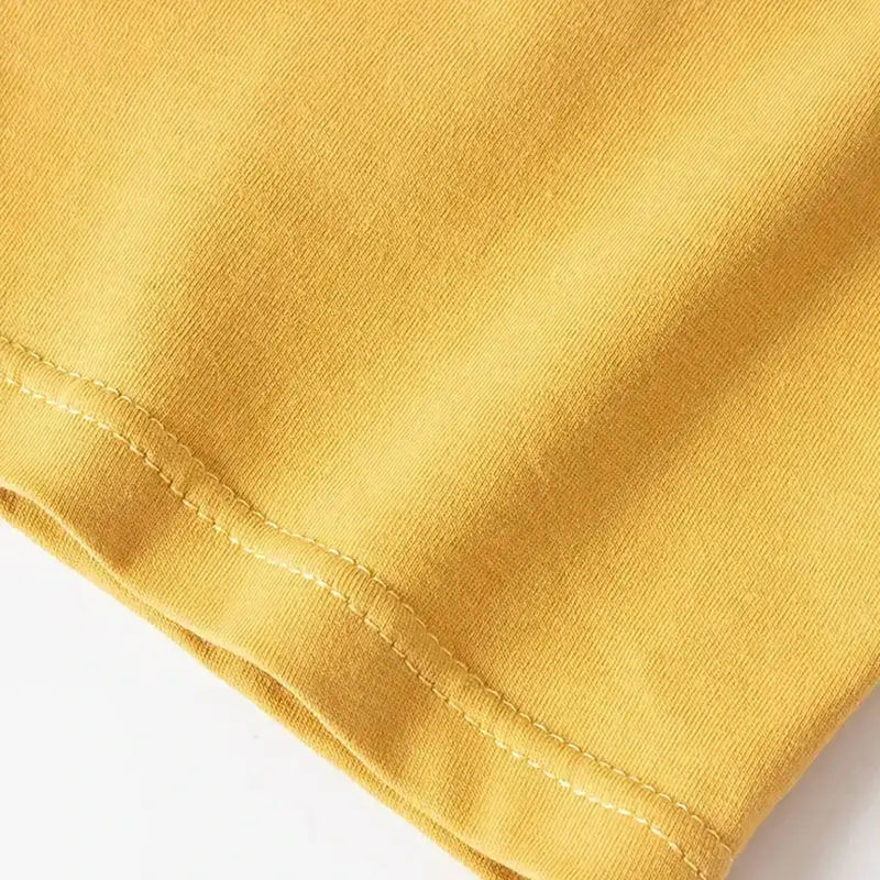 Yellow men's boxer shorts fabric close-up with visible stitched hem