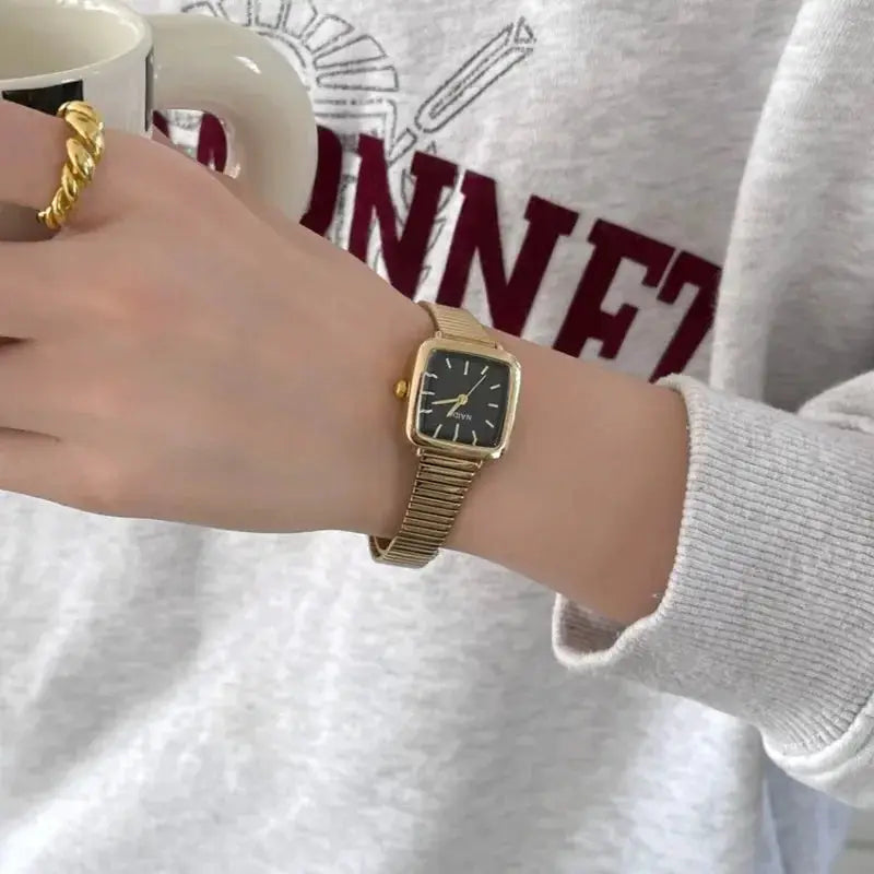 Women's gold-tone square quartz watch with black dial and adjustable stainless steel bracelet