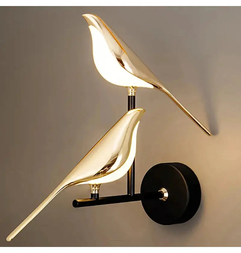 Modern LED wall lamp by Simples Market with two gold magpie bird silhouettes on a black wall sconce