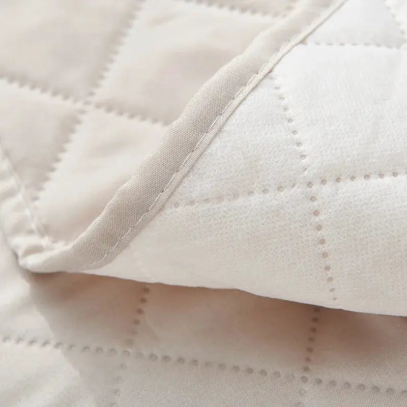 Anti-slip recliner seat slipcover in solid cream quilted fabric with edge-stitched seam for living room use