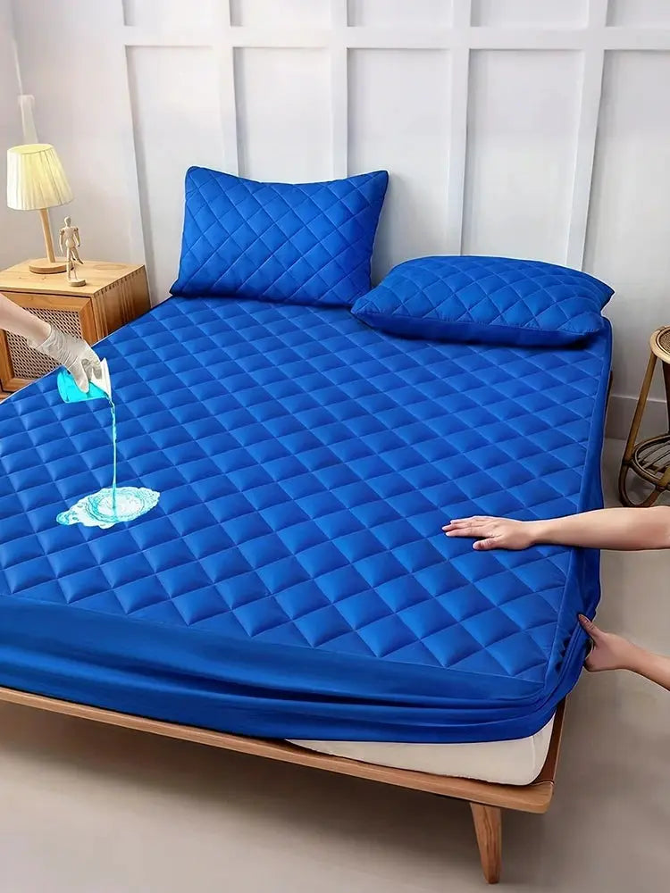 Mattress protector by Simples Market, blue quilted waterproof cover on bed with two pillows; breathable, noiseless.