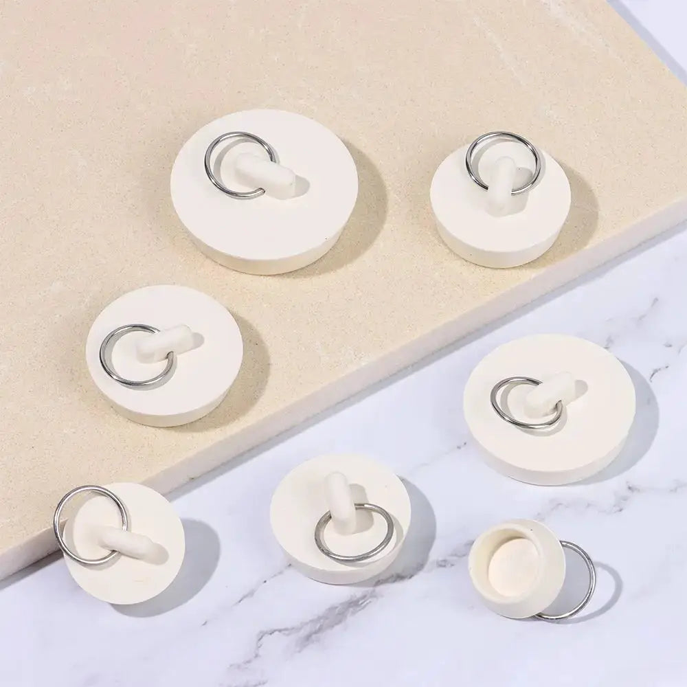 Set of white rubber drain plugs with metal rings for sinks and tubs