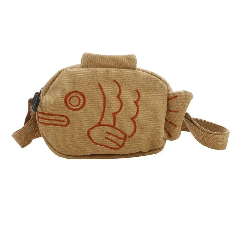 Fish shape canvas messenger bag in tan with embroidery accents, zippered crossbody bag.