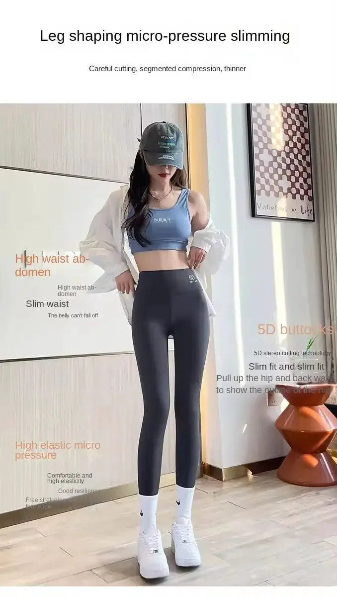 High-waisted yoga leggings, black, worn with a blue sports bra by a woman in a cap and sneakers