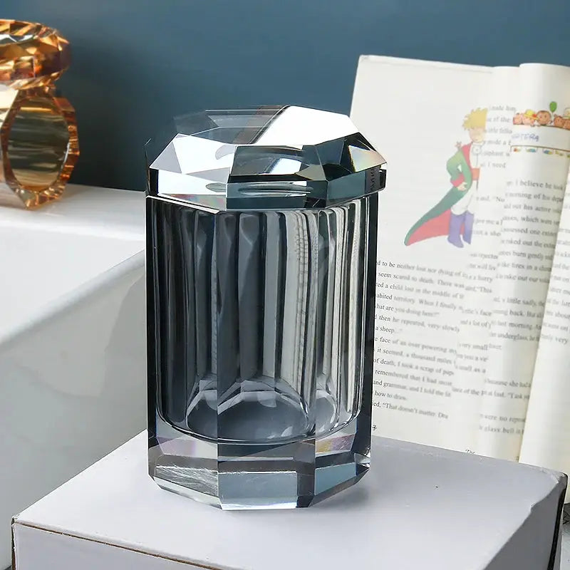 Glass lotion bottle with crystal-cut lid and faceted clear body for bathroom use.