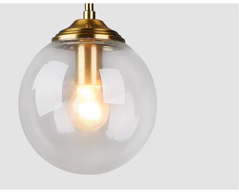 LED glass pendant lamp by Simples Market with clear globe and brass fitting, modern Nordic chandelier.