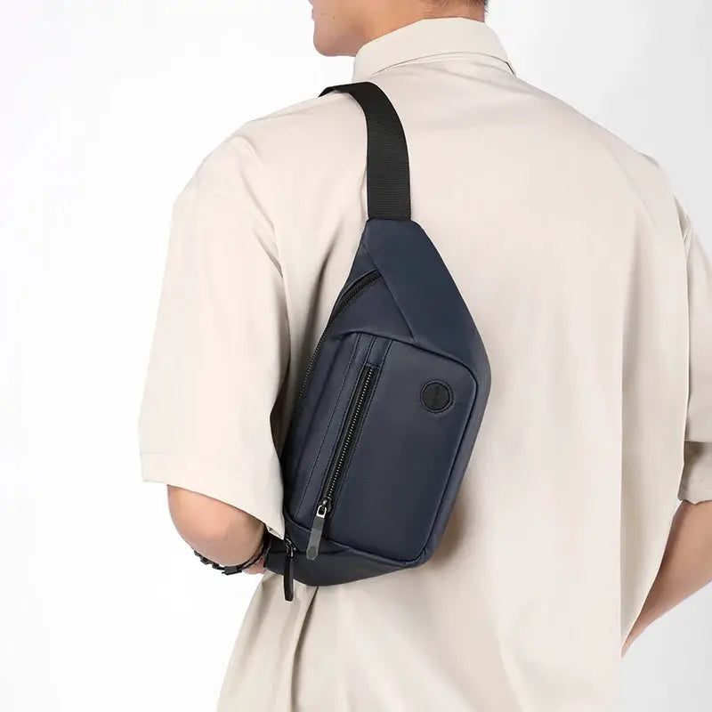 Unisex waterproof waist bag by Simples Market in navy with zip pocket, worn crossbody.