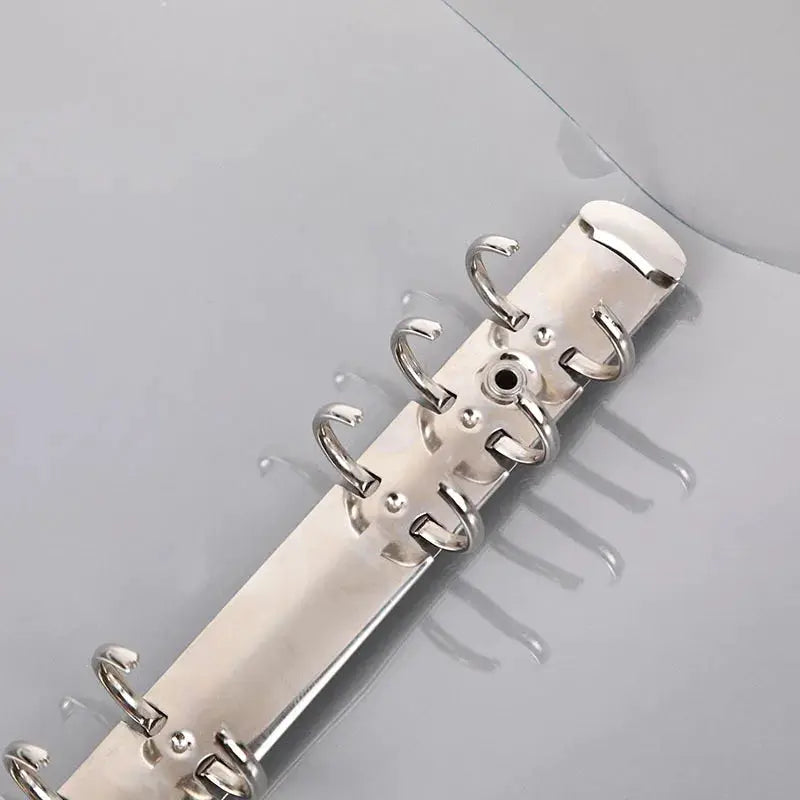 Six-ring metal binder spine on a transparent plastic binder for notebooks and planners