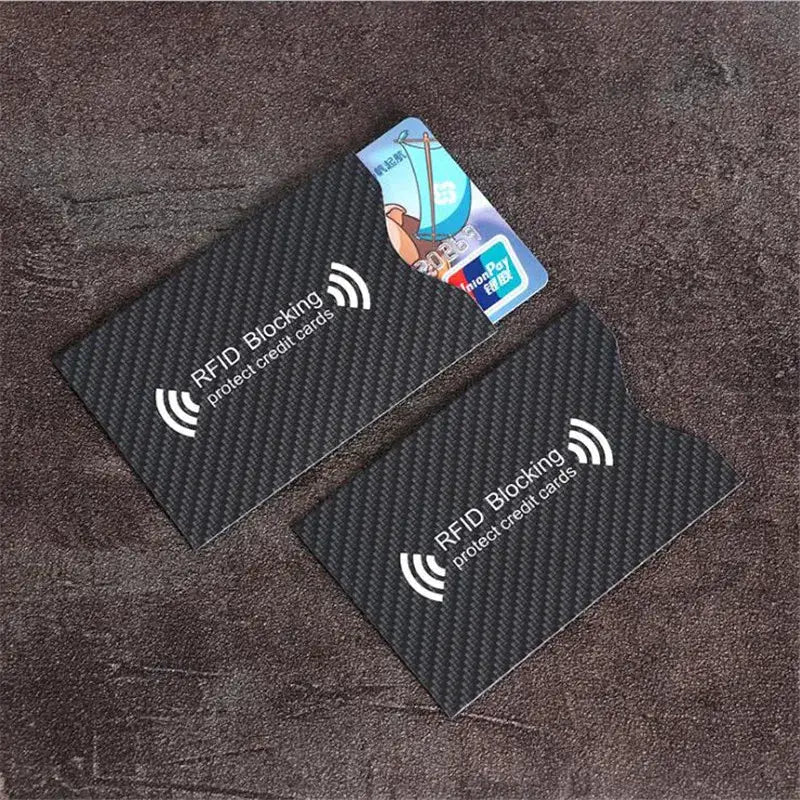 Simples Market RFID blocking card sleeves (2) in black carbon-textured finish, protecting credit and debit cards.