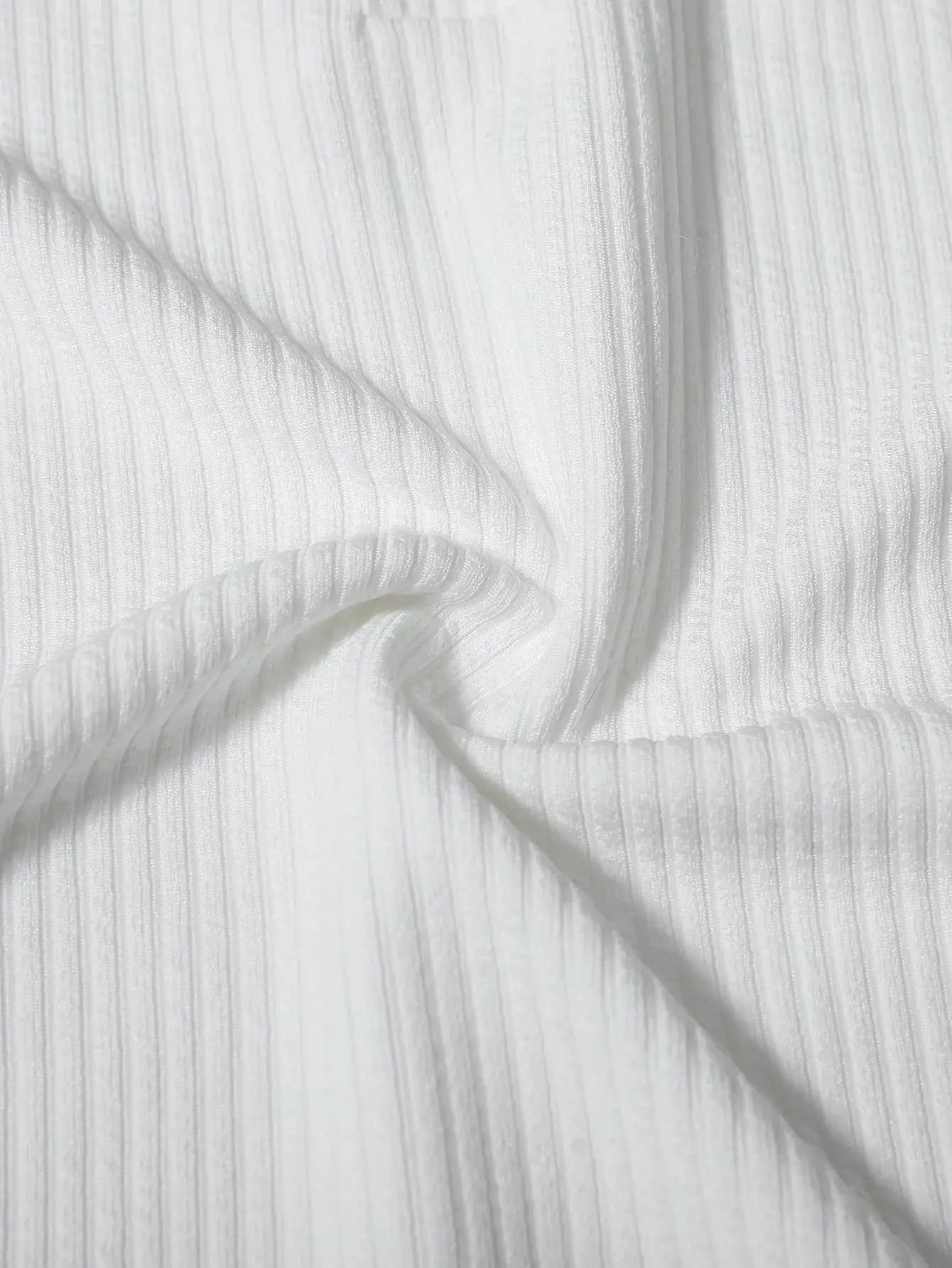 White ribbed polo shirt fabric close-up with textured vertical stripes